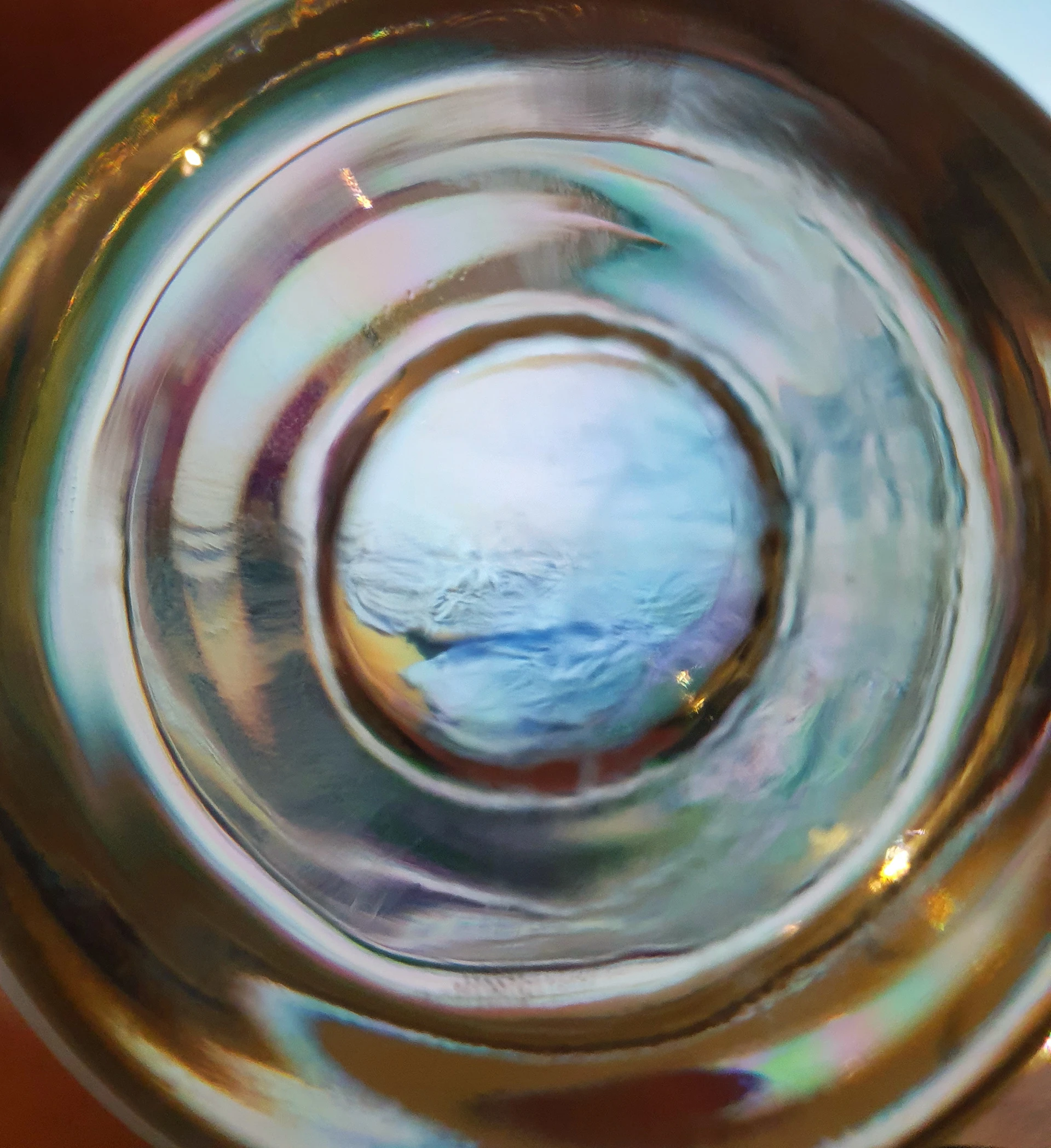 Photograph — a macro of a glassy amber-and-blue swirl
