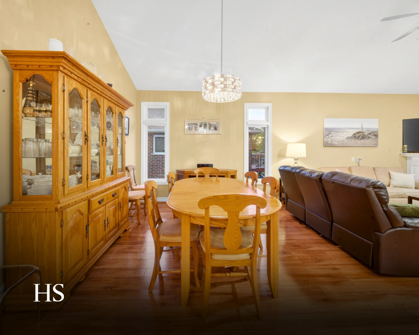 Dining room with an oak table and chairs, a china cabinet and a pendant light over the table