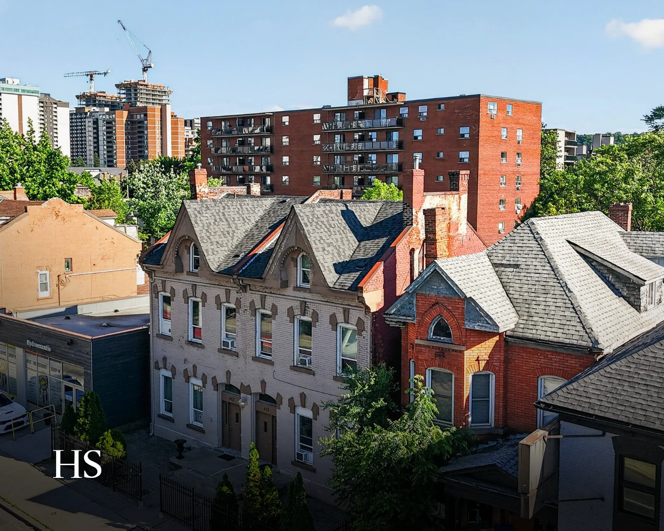 Drone view over the Victorian roofscape with a high-rise tower rising behind