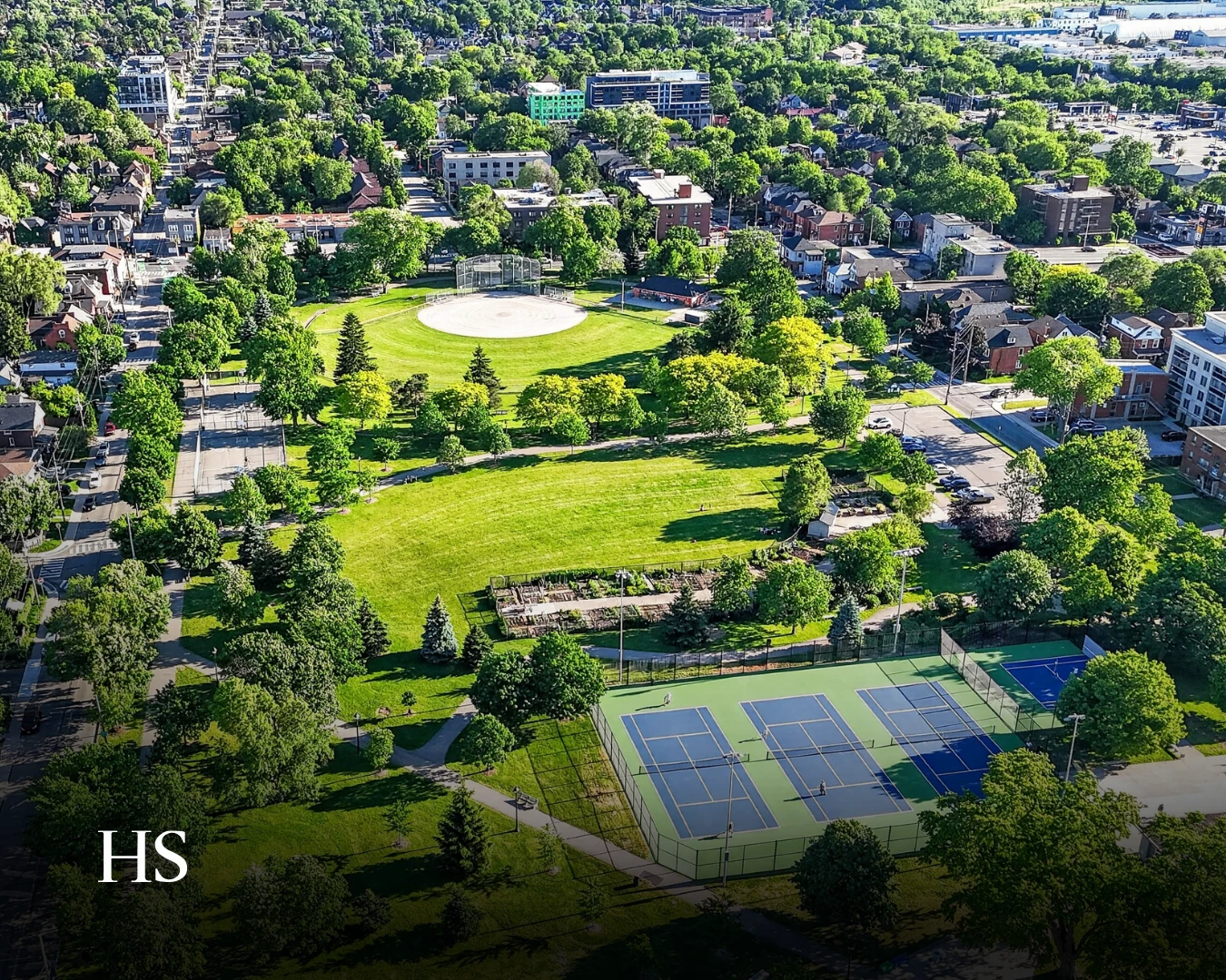 Drone view of a green park with tennis courts and a playground