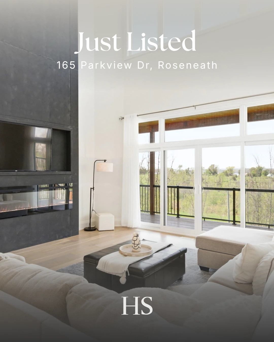Living room with cream sectional sofas and a dark leather ottoman, glass doors onto the deck, captioned "Just Listed — 165 Parkview Dr"