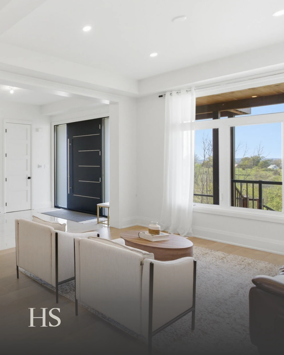 Great room with a pale sofa and coffee table beside a wall of windows